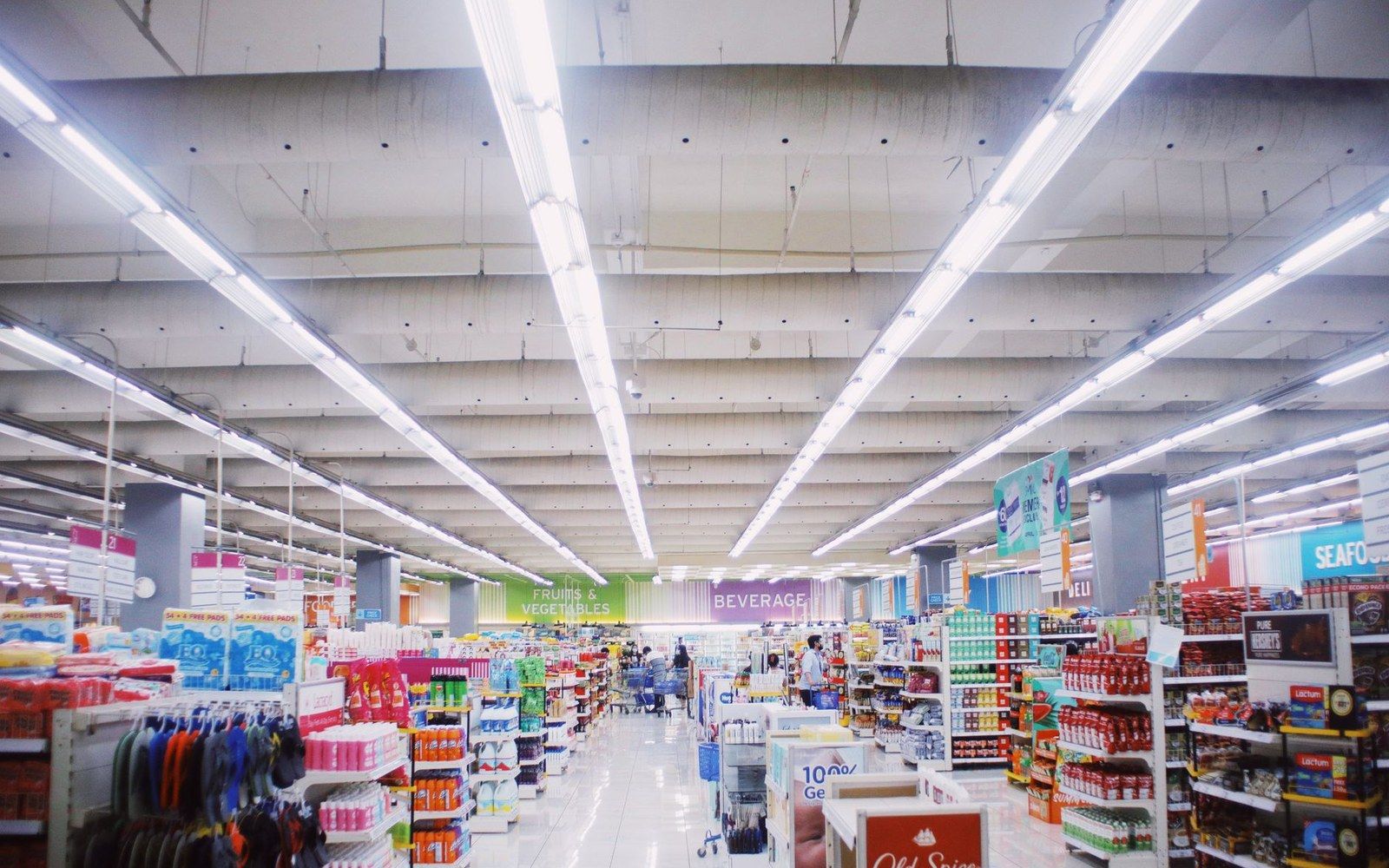 A supermarket chocolate aisle shot straight on at adult eye level, shelves fully stocked with named brand packaging, fluorescent light overhead